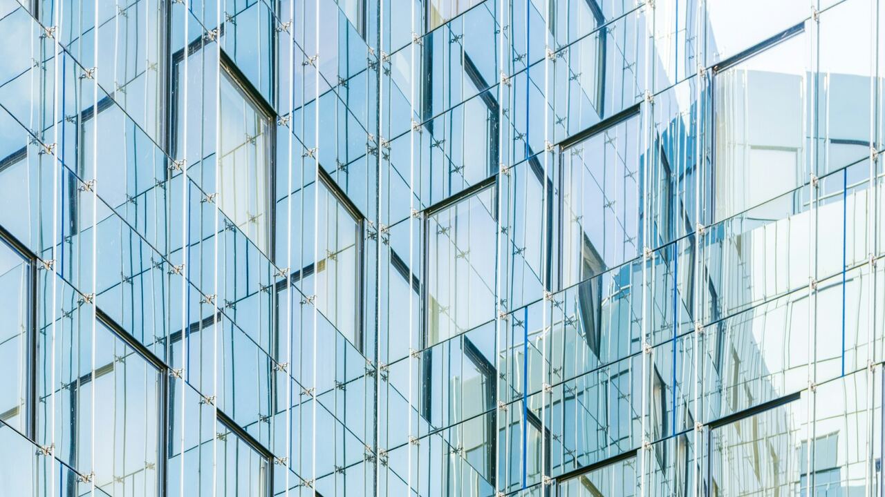 Modern glass facade reflecting the sky